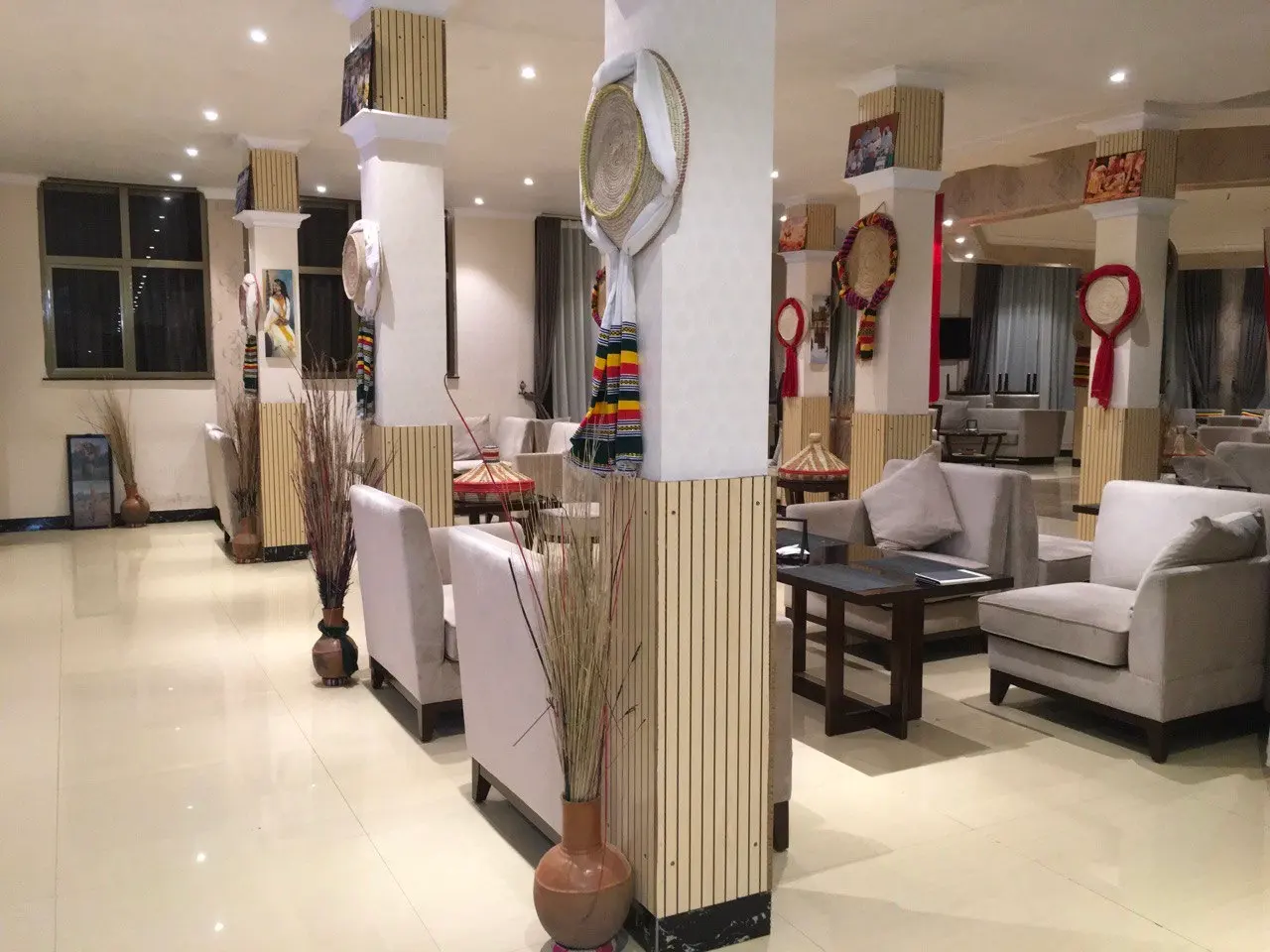 Restaurant lounge with white columns hung with woven baskets, and sofas