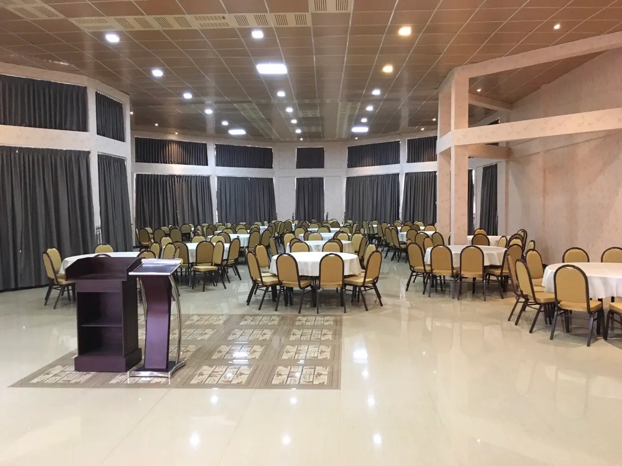 Conference hall with round tables, chairs and a lectern