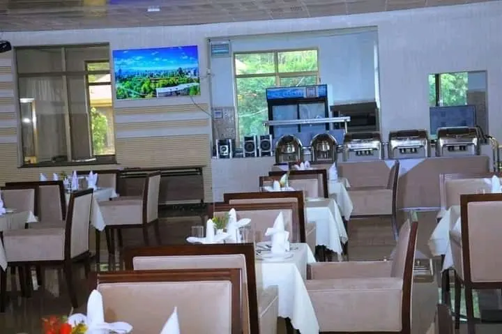 Restaurant dining hall with set tables and a buffet counter at the back