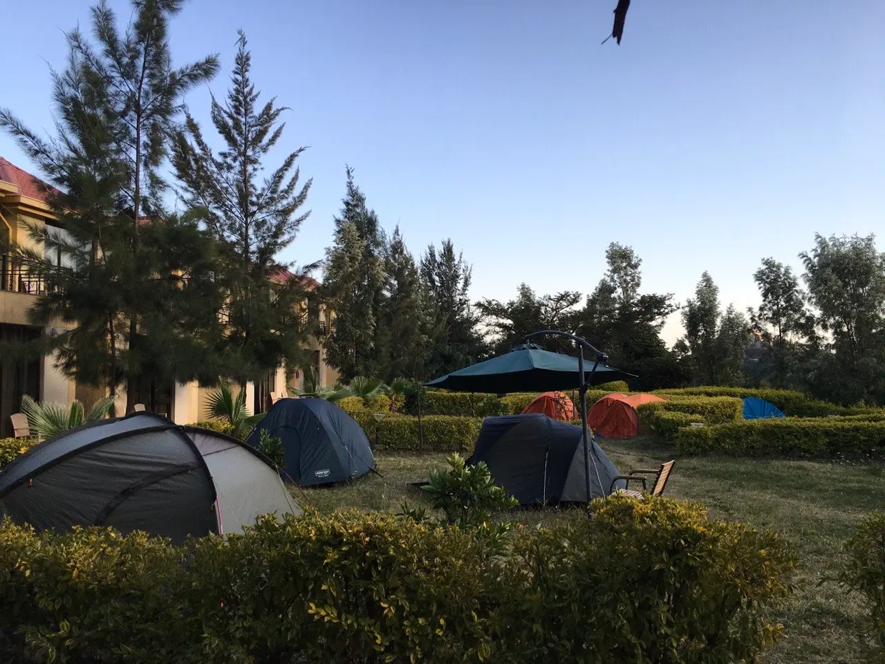 Tents pitched on the lawn in front of a two-storey guest building