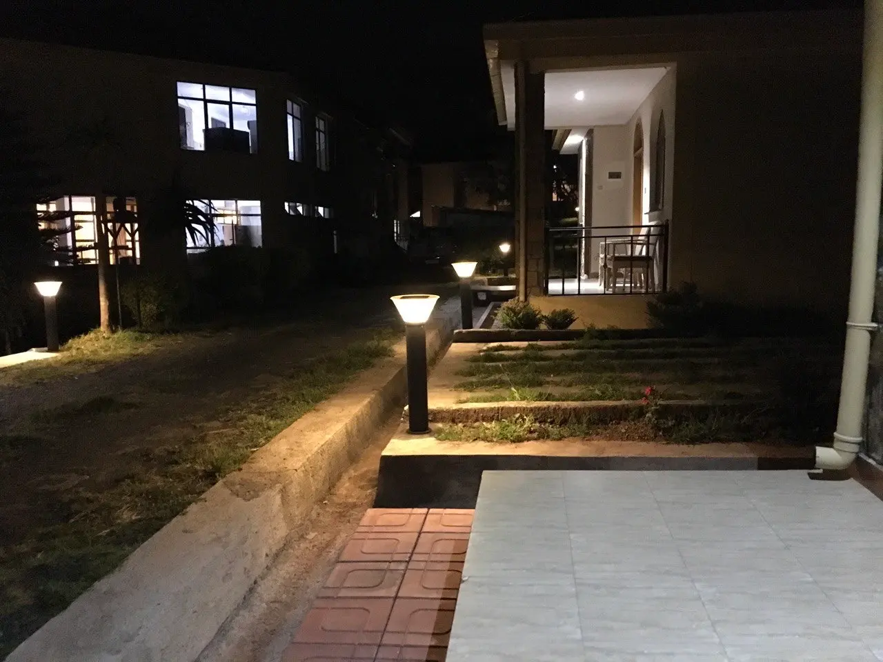 Garden path lit by solar lamps beside the guest buildings at night